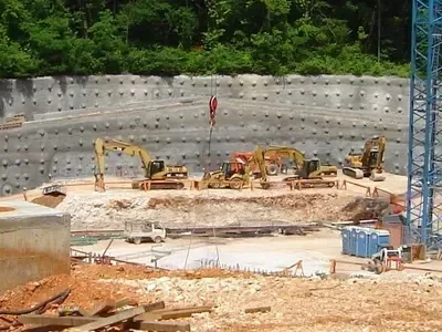 A construction site with heavy machinery engaged in dirt work.